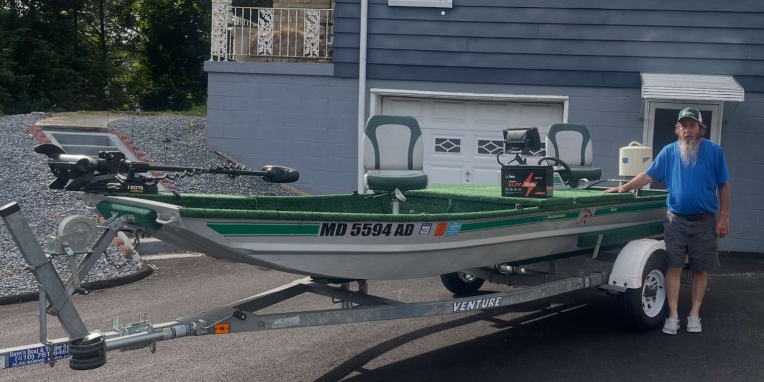 Maryland angler Carl Haugan with his upgraded Li Time lithium-powered bass boat on a trailer