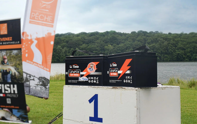Two LiTime 100Ah batteries sit on the first-place block of a winners' podium at the Peche Fishing Game event