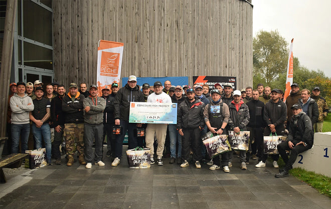 A large group photo of the participants at the Concours Fish Protect tournament, with the winner holding a prize check