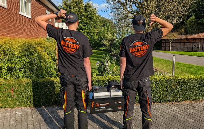 two men in LiTime t-shirts stand with a battery at the Hochschule Bielefeld event