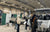 An indoor shot of the JDM Show, with several attendees viewing a display of fishing boats in an exhibition hall