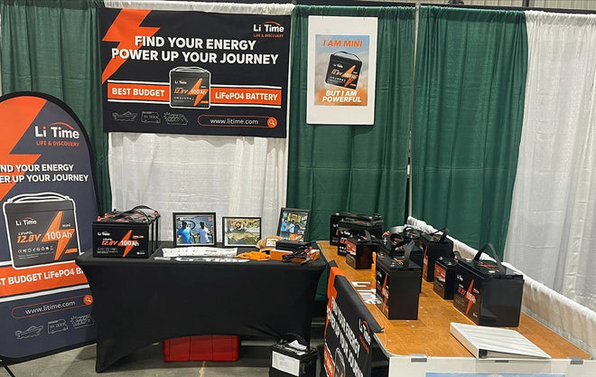 official LiTime booth at the JDM Show, featuring promotional banners and a wide display of LiFePO4 batteries