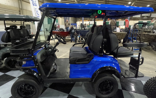 a golf cart with rugged wheels on display at the JDM Show