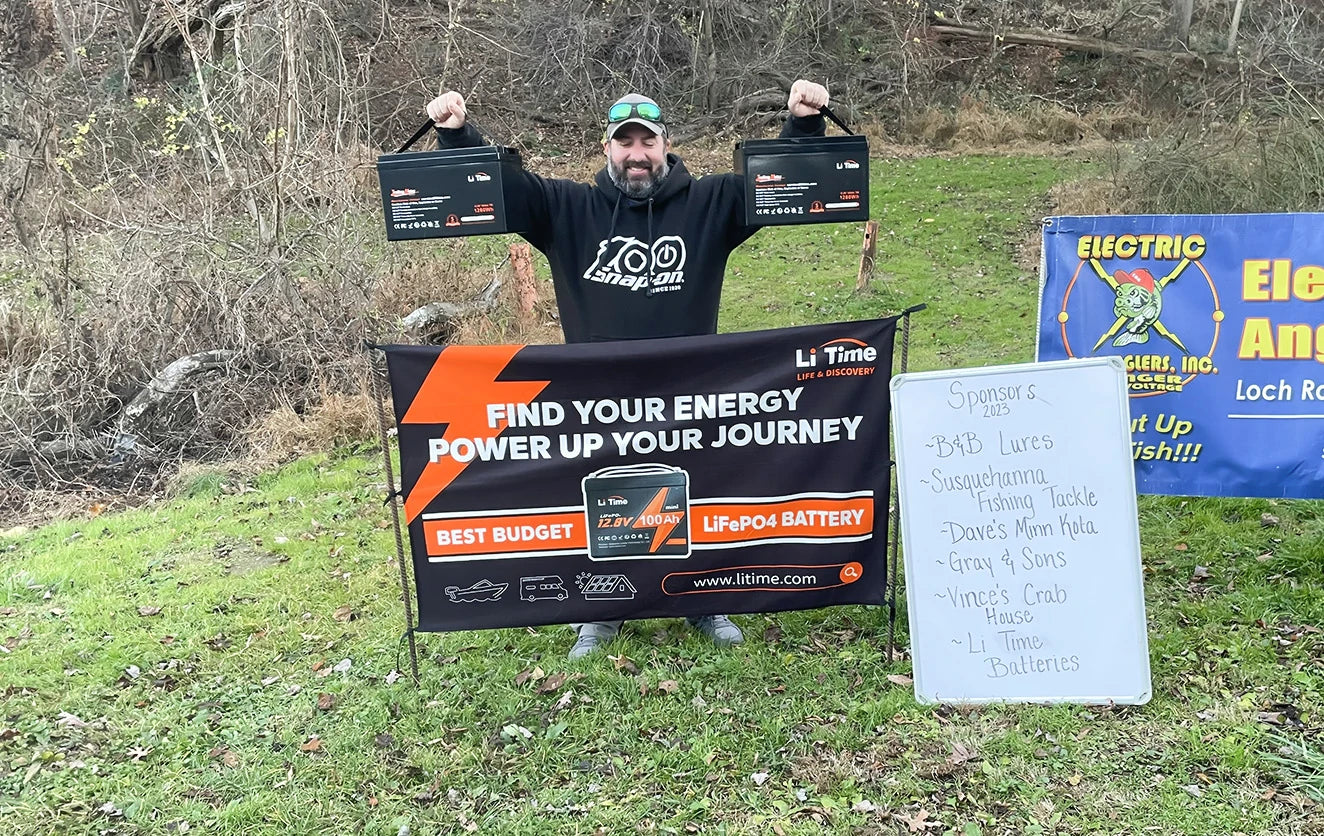 an angler holds up his prize of two Li Time batteries at the Electric Bass Anglers event 
