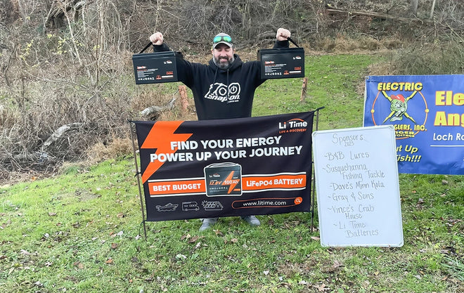 an angler holds up his prize of two Li Time batteries at the Electric Bass Anglers event 