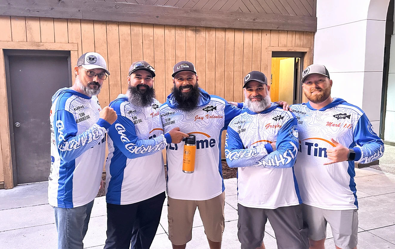 A team of five anglers posing together for a group photo in their matching blue and white Li Time fishing jerseys