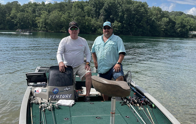 Two anglers pose on their bass boat while out on the water during the Electric Bass Anglers event