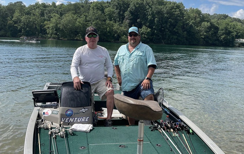 Two anglers pose on their bass boat while out on the water during the Electric Bass Anglers event