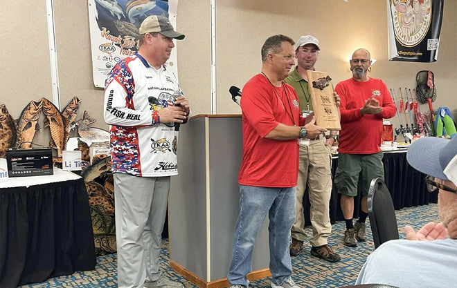 A veteran receives an award plaque on stage during a ceremony for the Heroes on the Water nonprofit kayak fishing event