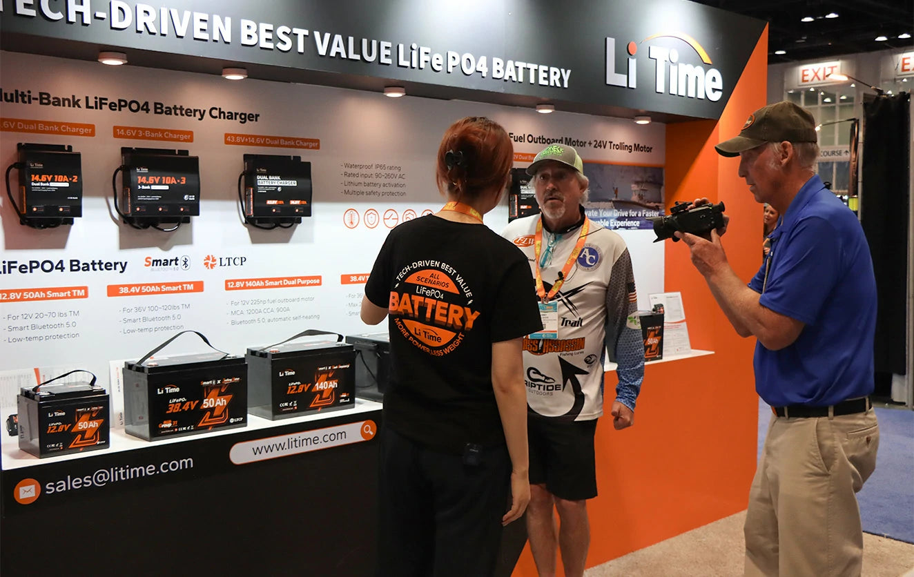 A LiTime staff member explains the lithium trolling motro batteries and chargers at the ICAST show.