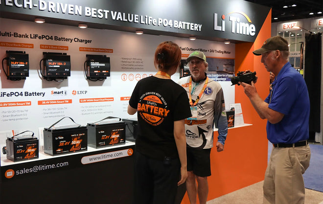 A LiTime staff member explains the lithium trolling motro batteries and chargers at the ICAST show.