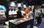 A LiTime staff member speaks with a visitor at the info desk at ICAST