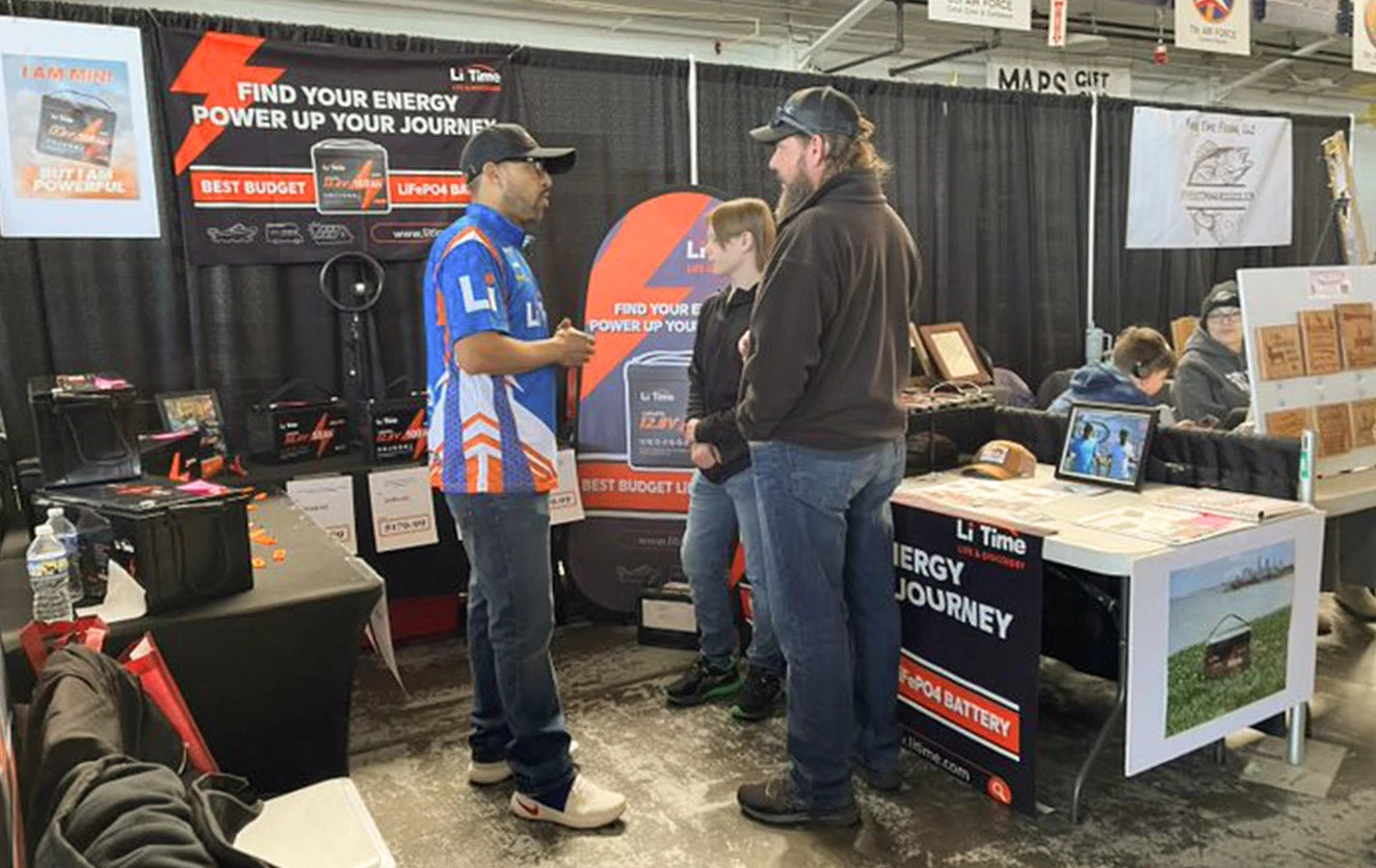 A father and son learn about Li Time batteries from a representative at the Fishing and Hunting Show
