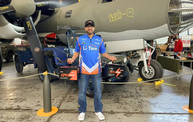 A Li Time rep poses with batteries in a unique, military-themed booth at a Fishing and Hunting Show