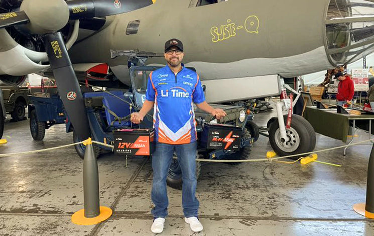 A Li Time rep poses with batteries in a unique, military-themed booth at a Fishing and Hunting Show