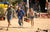 3 smiling competitors run towards the camera while carrying heavy LiTime batteries during a race at the Moonlanding event