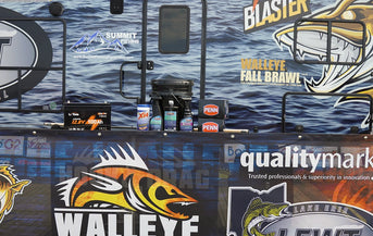A LiTime battery, PENN reel boxes, and other sponsor products displayed against the Walleye Fall Brawl event wrap