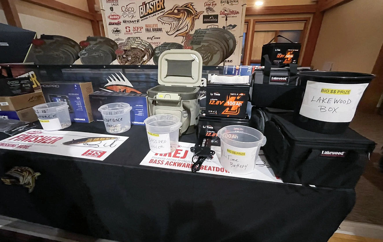 A fishing tournament prize table laden with gear from sponsors like LiTime, Lowrance, and Lakewood