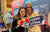 young fans at LiTime's Bass Master booth, holding 'I LOVE LiTime' and heart-shaped brand mascot signs