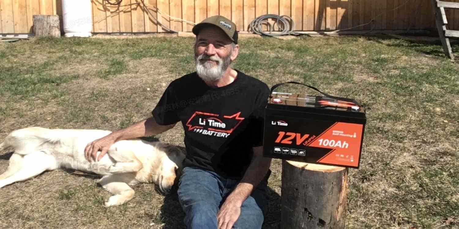 a man wearing a T-shirt with LiTime logo near the LiTime 12V 100Ah battery that with sel-heating function