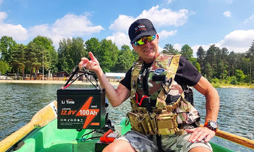 a man hoding a litime 100ah mini stting trolling motor battery in a boat showing its lightweight