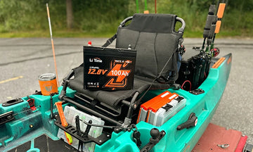 A LiTime 100Ah group 24 battery sits perfectly in the cargo area of a modern fishing kayak
