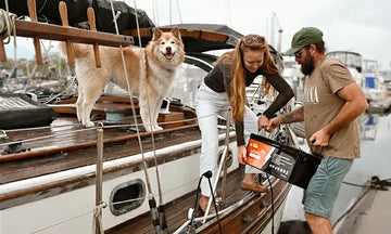 customers using a LiTime battery on a boat, with a dog nearby, highlighting positive LiTime customer feedback and experiences