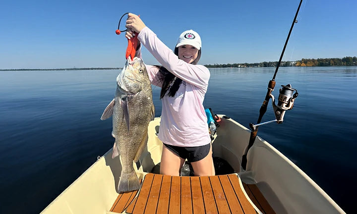 LiTime customer reviews featuring a woman holding a large fish while fishing on a calm lake, showcasing outdoor enjoyment